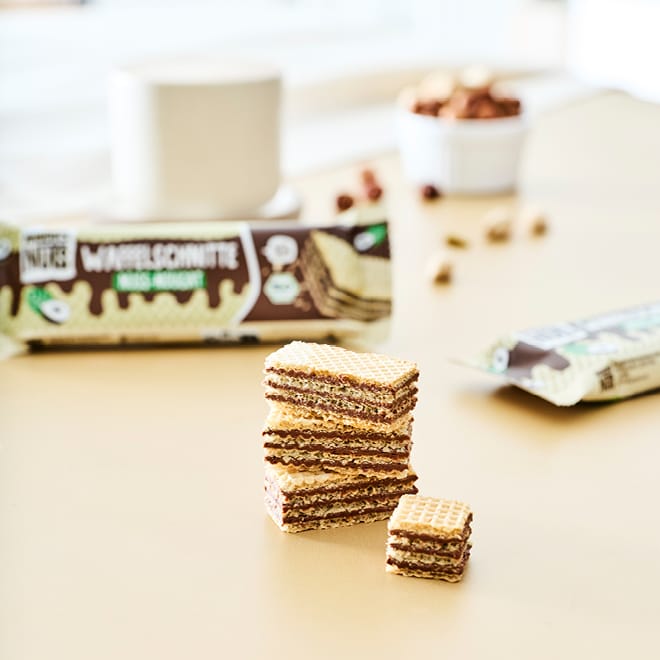 Bio Waffelschnitte Mixed Box Nuss-Nougat & Pistazie, gestapelt auf einem Tisch